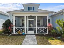 Charming home featuring a spacious screened-in front porch, stone walkway, and well-maintained landscaping at 562 Landshark Blvd, Daytona Beach, FL 32124