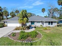 Charming single-story home with a well-manicured lawn and a beautiful garden in front at 13 Sandcastle Dr, Ormond Beach, FL 32176