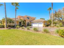 Stunning, yellow, two-story home with a three-car garage and lush tropical landscaping at 20 Promenade At Lionspaw, Daytona Beach, FL 32124