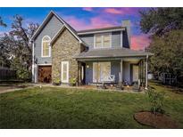 Charming two-story home with stone accents and a welcoming front porch swing at 2057 Hillview Circle, Deltona, FL 32738