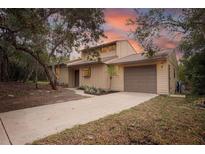 Two-story home featuring mature landscaping, two-car garage, and freshly painted exterior at 241 Bayou Vista St, Debary, FL 32713