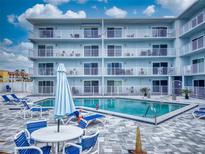 Bright condo building offers a luxurious pool with plenty of seating for residents to relax and enjoy the sun at 3700 S Atlantic Ave # 111, New Smyrna Beach, FL 32169