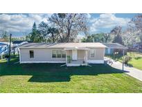 Charming one-story home featuring a well-manicured lawn and covered parking at 55634 Sam St, Astor, FL 32102