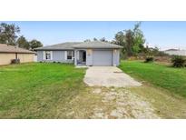 Charming single-story home featuring a gray exterior, attached garage, and well-maintained front lawn at 599 S Cedar Ave, Orange City, FL 32763