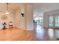Bright living room with light wood floors, ceiling fan, and doorways to the kitchen and outdoor patio at 6152 Sequoia Dr, Port Orange, FL 32127