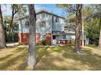 Charming two-story home with light blue siding, red brick, and a well-maintained front yard at 749 E Wisconsin Ave, Orange City, FL 32763