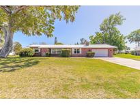Charming brick home featuring a metal roof and a lush green lawn, set beneath a clear blue sky at 953 Pineapple Rd, South Daytona, FL 32119