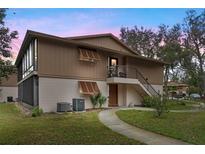 Charming two-story condo with wood accents, exterior stairway, and landscaped surroundings at 100 Sweetgum Woods Ct # 11D, Deltona, FL 32725