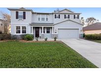 Charming two-story home featuring a manicured lawn and welcoming front entrance at 1318 Pup Fish Ln, Deland, FL 32724