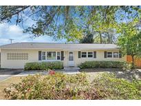 Charming single-story home with blue shutters, flower beds and light-yellow painted exterior at 141 N Mcdonald Ave, Deland, FL 32724
