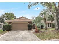 Charming single-story home featuring stone accents, a two-car garage, and mature landscaping at 1651 Kenlyn Dr, Longwood, FL 32779
