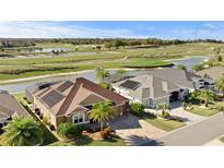 Waterfront home with solar panels and well manicured landscaping overlooking a golf course at 3432 Wise Way, The Villages, FL 32163