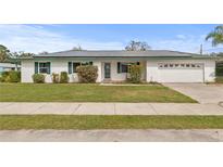 Charming single-story home featuring a well-maintained lawn, solar panels and attached garage at 445 Virginia Ave, St Cloud, FL 34769