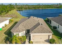 Beautiful single-Gathering home with a two-car garage and well-maintained landscaping in front of a lake at 515 Stowers Dr, New Smyrna Beach, FL 32168