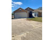 Charming single-story home featuring a two-car garage, neutral paint, and a well-maintained front yard at 7879 Camlyn Ct, Orlando, FL 32818