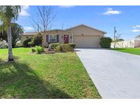 Charming single-story home featuring a well-manicured lawn and a spacious two-car garage at 826 W Gaucho Cir, Deltona, FL 32725
