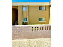 Tan condo building featuring multiple windows and concrete perimeter wall at 1000 Lake Of The Woods Blvd # 104F, Casselberry, FL 32730