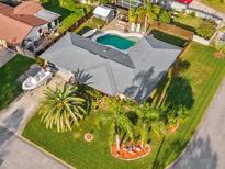 Aerial view of a home with a well-manicured lawn, complemented by a pool and a boat in the driveway at 1424 Breaks Way, Port Orange, FL 32127