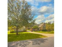 Inviting single story home with well maintained lawn, mature trees, and brick accents on driveway and covered walkway at 238 Crooked Tree Trl, Deland, FL 32724