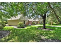 Side view of home with a detached garage and beautifully landscaped yard with large trees at 238 Crooked Tree Trl, Deland, FL 32724