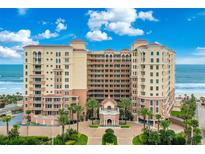Stunning exterior view of a beachfront condominium with meticulous landscaping and beautiful blue skies at 2515 S Atlantic Ave # 401, Daytona Beach Shores, FL 32118