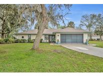 Charming single-story home with well-manicured lawn, lush landscaping, and attached two-car garage at 2557 Shiprock Ct, Deltona, FL 32738