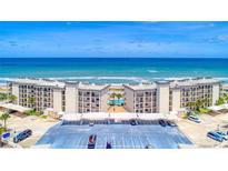 Stunning aerial view of beachfront condos with a pool, parking, and ocean views at 2700 Ocean Shore Blvd # 305, Ormond Beach, FL 32176