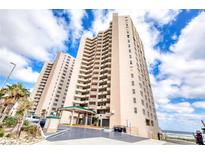 Stunning exterior shot of a beachfront condo building with a covered entry and well-maintained landscaping at 3315 S Atlantic Ave # 705, Daytona Beach, FL 32118