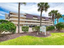Bent Palm Club Condo features a multi-level building with parking and lush landscaping near the sign at 935 Ocean Shore Blvd # 4010, Ormond Beach, FL 32176