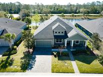 Stunning lakefront home with a three-car garage, paver driveway, and manicured landscaping at 1204 Draycott St, Ormond Beach, FL 32174