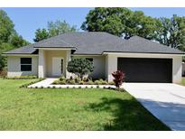 Charming single-story home featuring a well-manicured lawn, inviting entryway, and a spacious two-car garage at 1275 16Th St, Orange City, FL 32763