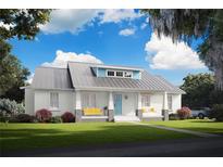 Charming single-story home with metal roof, inviting porch with swing, and beautifully landscaped front yard at 132 E Craig Ave, Lake Helen, FL 32744