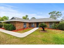 Charming single-story brick home featuring a well-maintained lawn and cozy front entrance at 1957 Monterey Dr, Deltona, FL 32738
