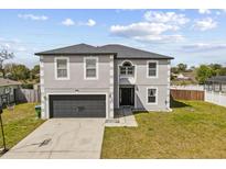 Two-story home featuring a two-car garage and a well-maintained lawn at 1978 S Old Mill Dr, Deltona, FL 32725