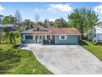 Charming single-story home with a well-maintained lawn and a spacious driveway at 2216 Umbrella Tree Dr, Edgewater, FL 32141