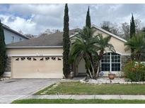 Charming single-story home featuring stone accents, a two-car garage, and lush landscaping at 2238 Windcrest Lake Cir, Orlando, FL 32824