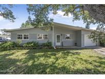 Charming single-story home with a well-maintained lawn and mature trees providing shade at 2821 Oak Lea Dr, South Daytona, FL 32119