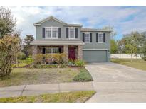 Charming two-story home with well-maintained lawn, stone accents, and attached garage at 3894 Arborvitae Way, Deland, FL 32724