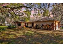 Charming single-story home featuring a stone facade and beautiful landscaping under a large, mature, shade tree at 4612 Reynosa Sw Dr, Winter Haven, FL 33880
