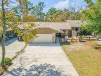 Charming single-story home featuring a two-car garage, stone accents, and a well-maintained front yard at 49 Crooked Pine Rd, Port Orange, FL 32128