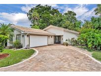 Inviting single-story home with a tile roof, brick driveway, and well-manicured landscaping at 509 Osprey Ln, Winter Springs, FL 32708