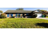 Charming brick home with blue shutters and well-maintained front yard at 1013 Matterhorn St, Deltona, FL 32725