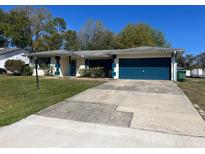 Charming single-story home featuring a blue garage door and a concrete driveway at 1096 N Harbor Dr, Deltona, FL 32725