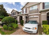 Inviting townhome featuring a well-maintained yard, front-entry garage, and a charming balcony at 1183 Honey Blossom Dr, Orlando, FL 32824