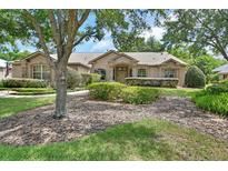 Well-maintained home with lush landscaping, a sidewalk, and stone accents on the facade at 1491 W Silver Hammock, Deland, FL 32720