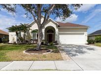Charming single-story home featuring a well-manicured lawn, mature trees, and a welcoming two-car garage at 1751 Creekwater Blvd, Port Orange, FL 32128