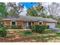 Charming brick home with a well-maintained lawn and mature landscaping at 1810 W Cooper Dr, Deltona, FL 32725