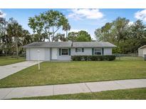Charming single-story home with a well-maintained lawn and attached garage at 1986 Big Oak Dr, South Daytona, FL 32119