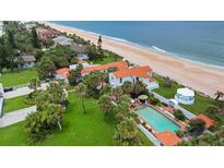 Stunning aerial view of an oceanfront home with a pool, gazebo, and beautifully manicured lawn at 201 Ocean Shore Blvd, Ormond Beach, FL 32176