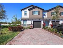 Charming townhome featuring brick paver driveway and manicured landscaping at 206 Beautyberry Ln, Sanford, FL 32771